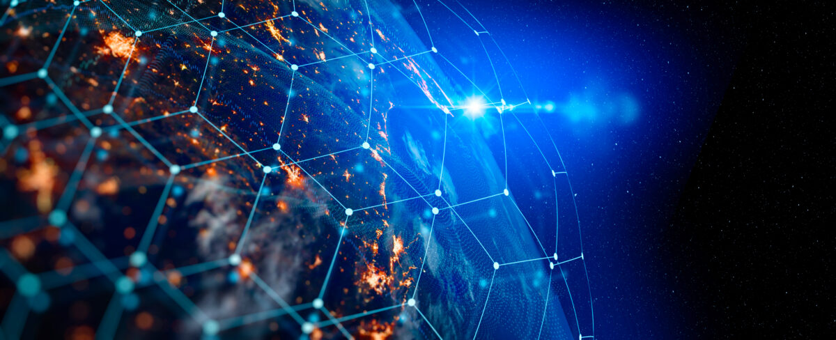 A view of Earth from space at night, highlighting illuminated cities. A digital network overlay forms a hexagonal grid over the planet, with bright blue light and stars in the background, suggesting global connectivity and technology.