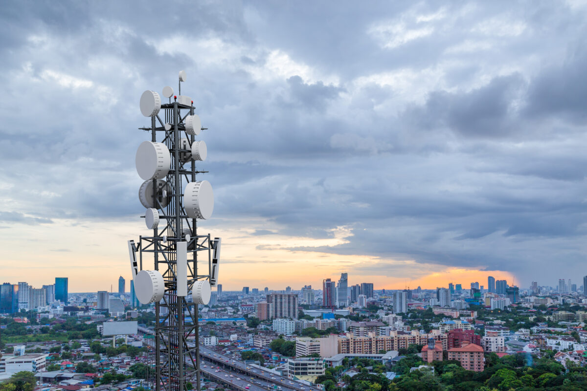 A telecommunication tower with 5G cellular network antenna on city background