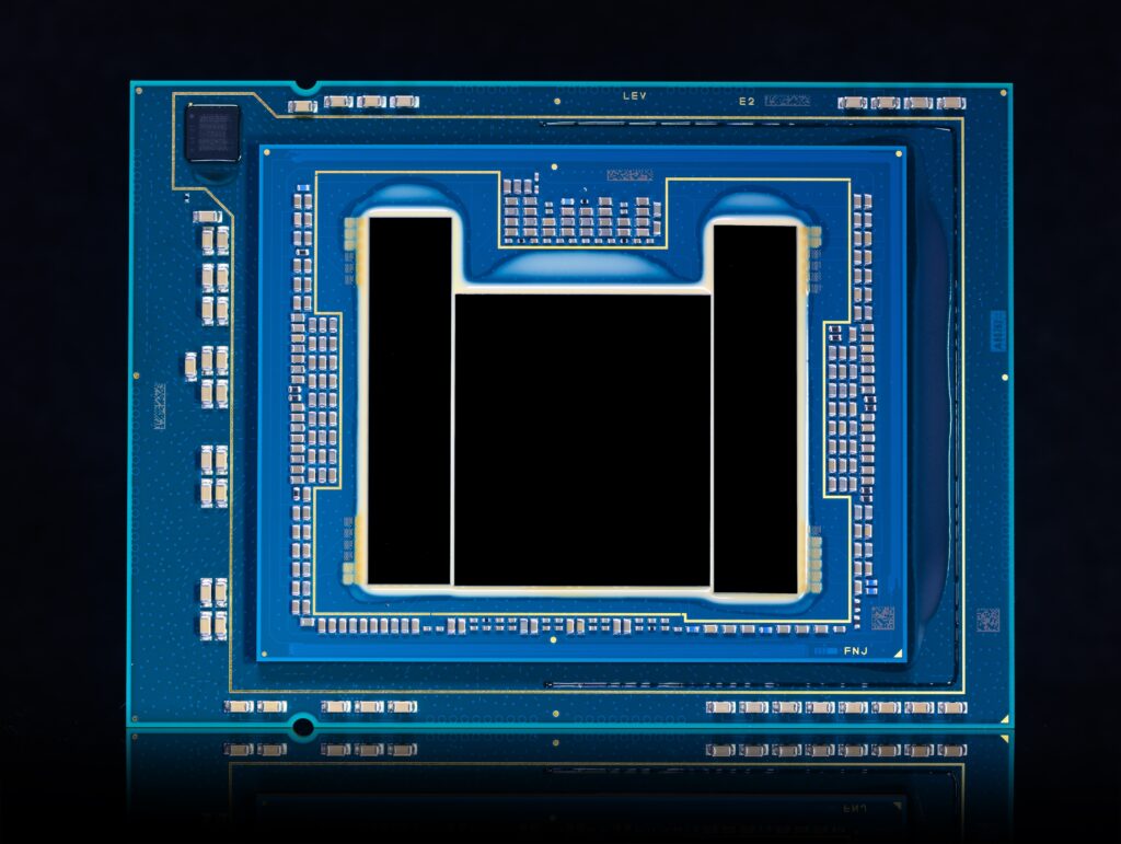 Close-up image of a computer processor with a blue and silver design. Numerous small components and circuits are visible on its surface, set against a dark background.